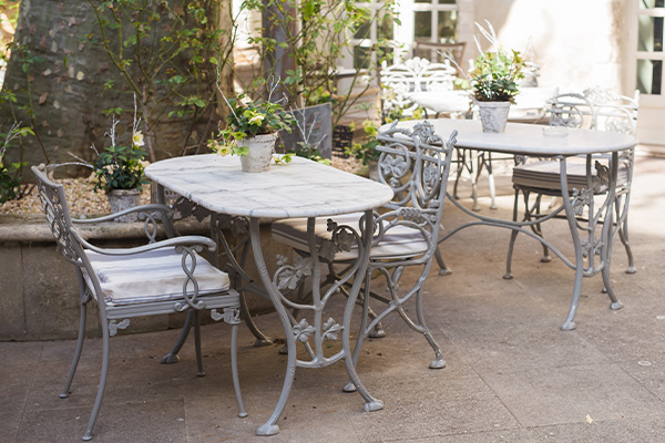 outdoor dining area with metal tables and chairs decorated with small potted plants suitable for gatherings under the sun seven enchanting seating options