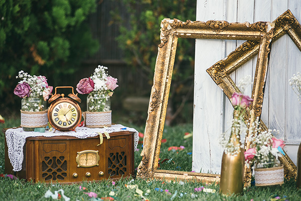 vintage decor with a wooden radio antique clock and picture frames surrounded by flowers and greenery 4 decorative elements elegant setup