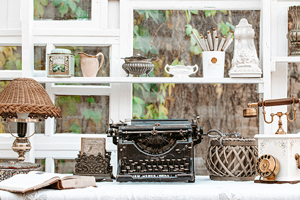 vintage typewriter on a wooden table surrounded by decorative items and a lamp creating a nostalgic atmosphere for timeless writing and creativity